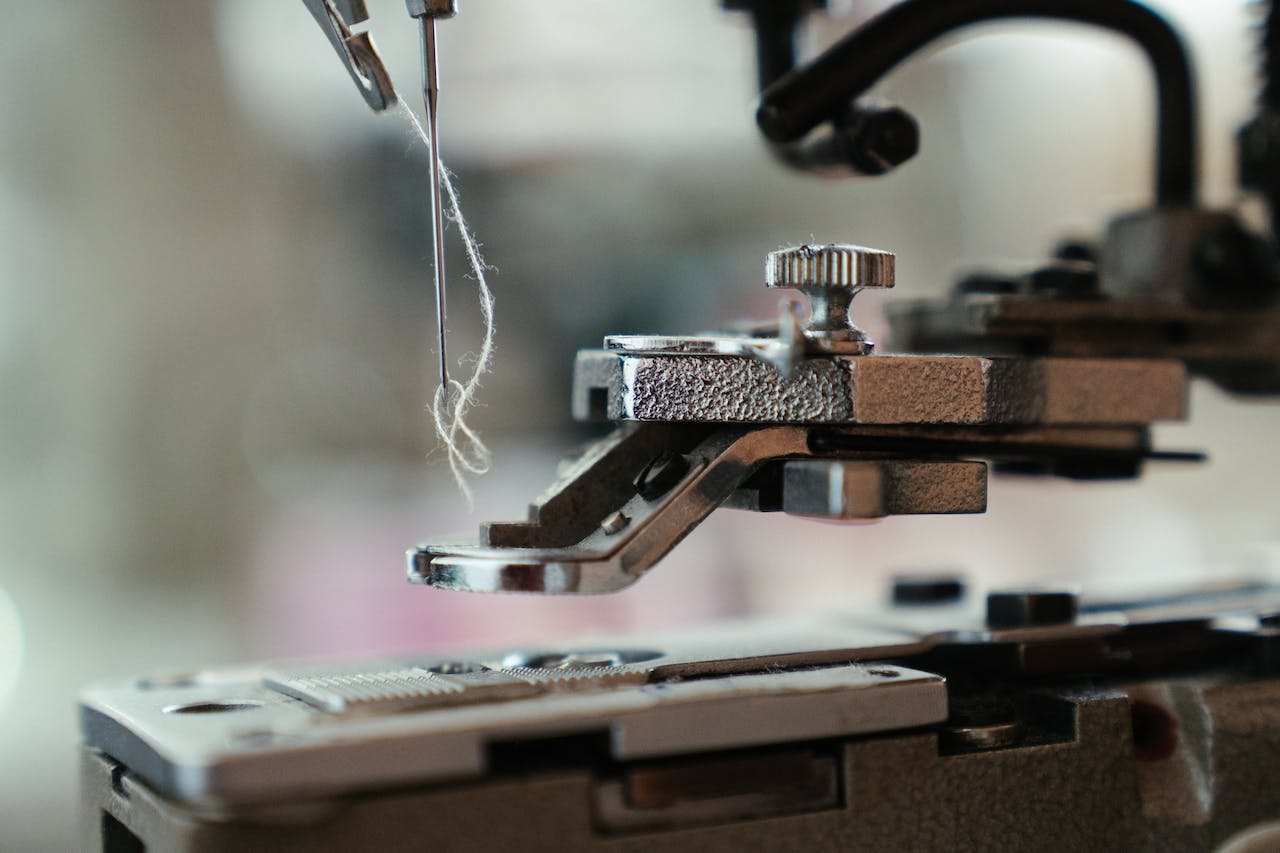 close up photo of string in a needle attached to a sewing machine