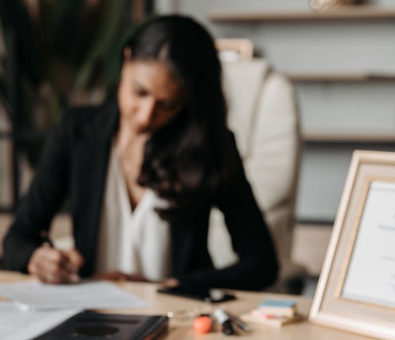 woman working at desk with certification framed