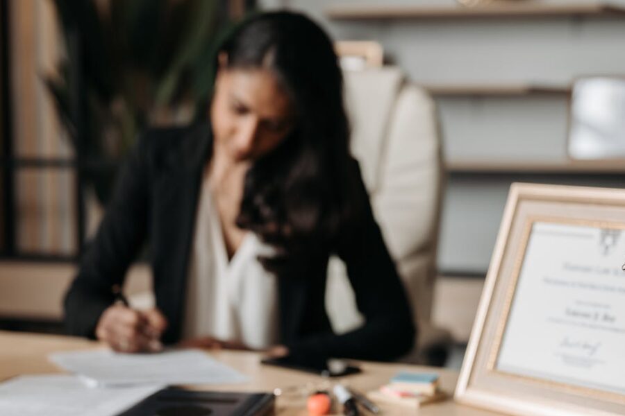 woman working at desk with certification framed