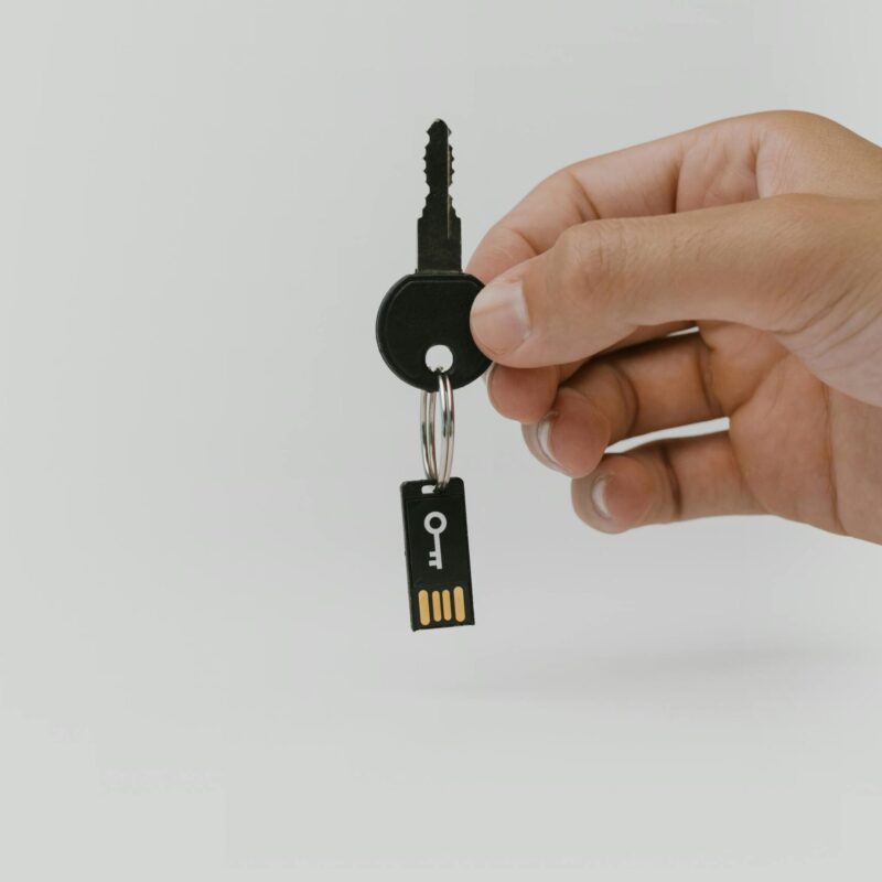 person holding key and usb drive