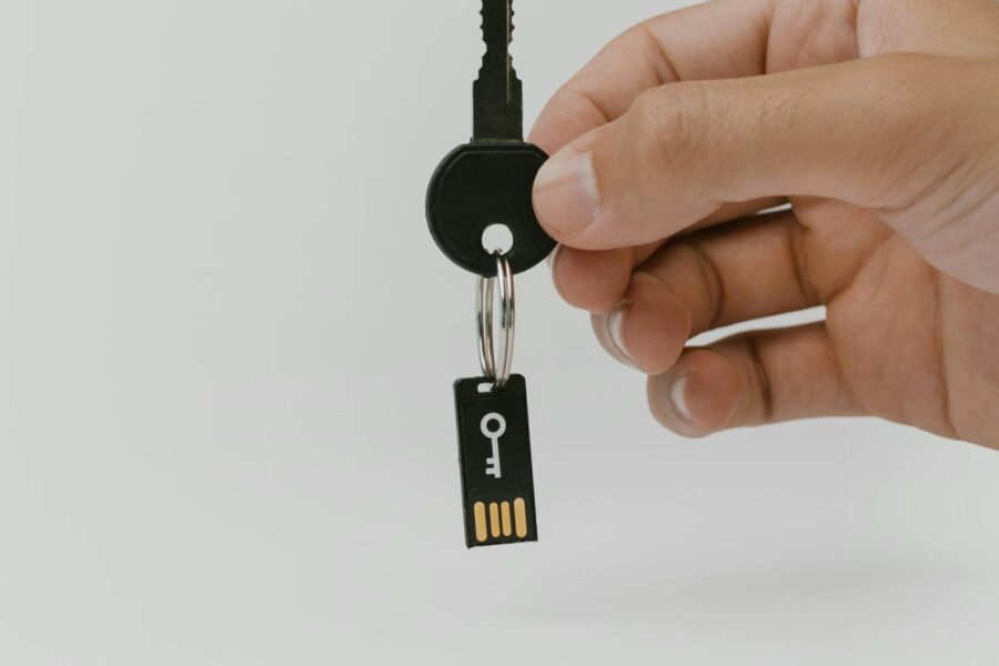 person holding key and usb drive