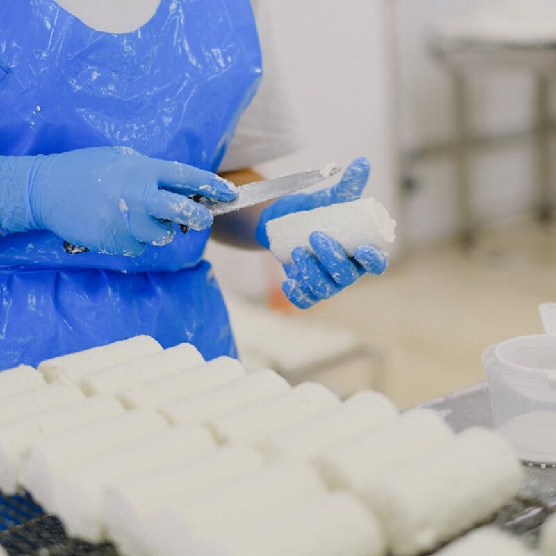 worker shaping cheese in factory